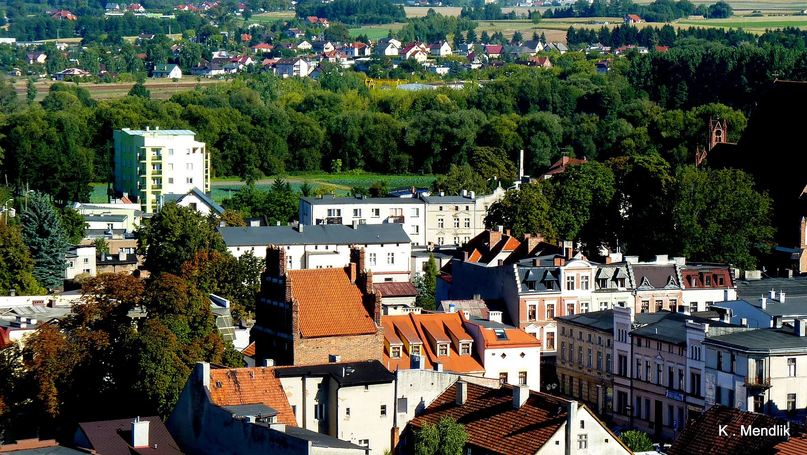 Panorama Brodnicy z wieży zamkowej, Brama Chełmińska, czerwone dachy i zieleń w tle