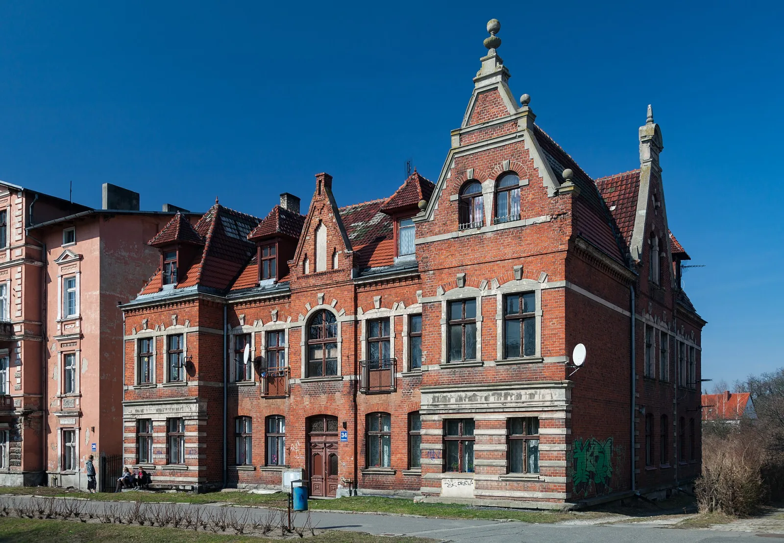 Ceglany budynek przy ulicy Solankowej 34 w Inowrocławiu z ozdobnymi szczytami i wysoką wieżyczką
