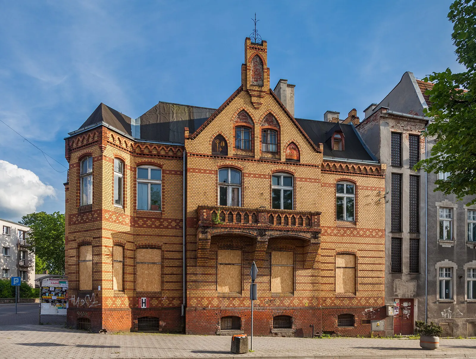 Ozdobna elewacja kamienicy przy Braterstwa Narodów 60 w Kwidzynie, z balkonem, szczytami i ceglanymi detalami