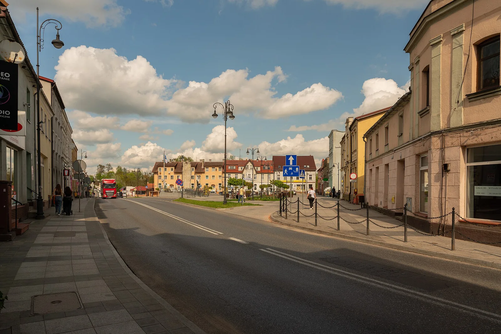 Zabudowa centrum Sępólna Krajeńskiego wokół placu Wolności, kamienice i ulica pod chmurami