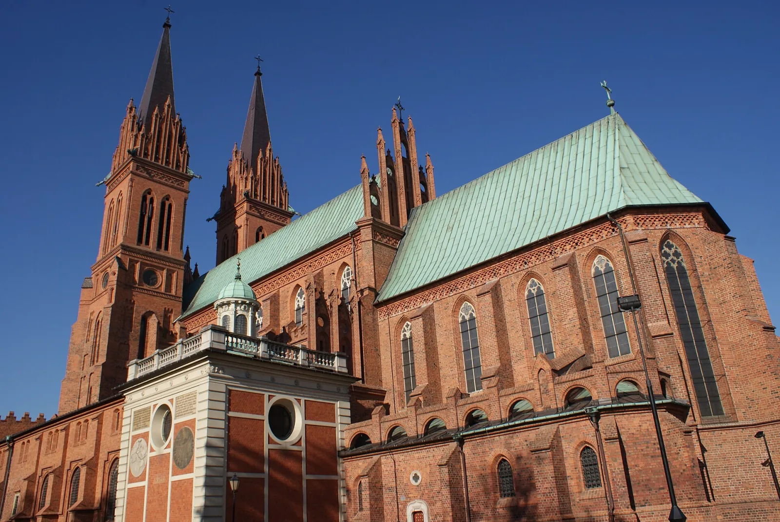 Ceglane wieże i zielony dach katedry Wniebowzięcia Najświętszej Maryi Panny we Włocławku