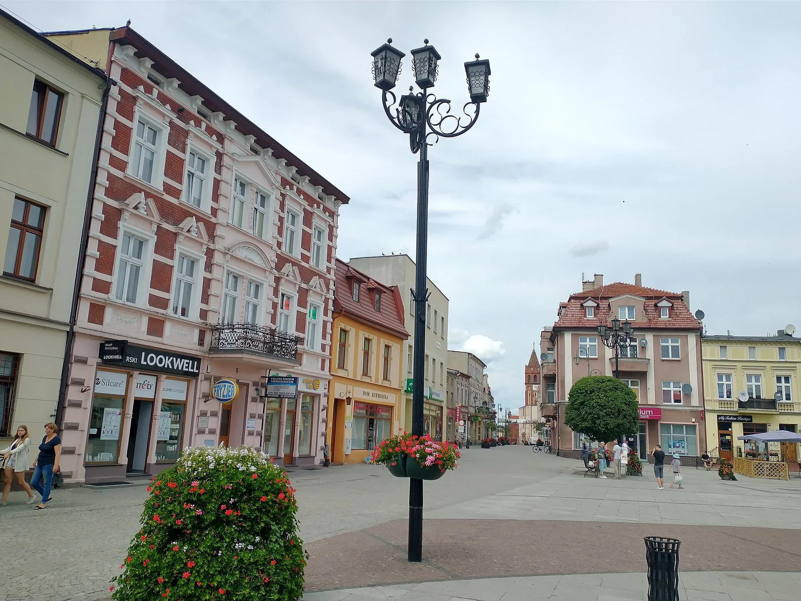 Kolorowe kamienice przy rynku w Żninie i ozdobna latarnia na pierwszym planie